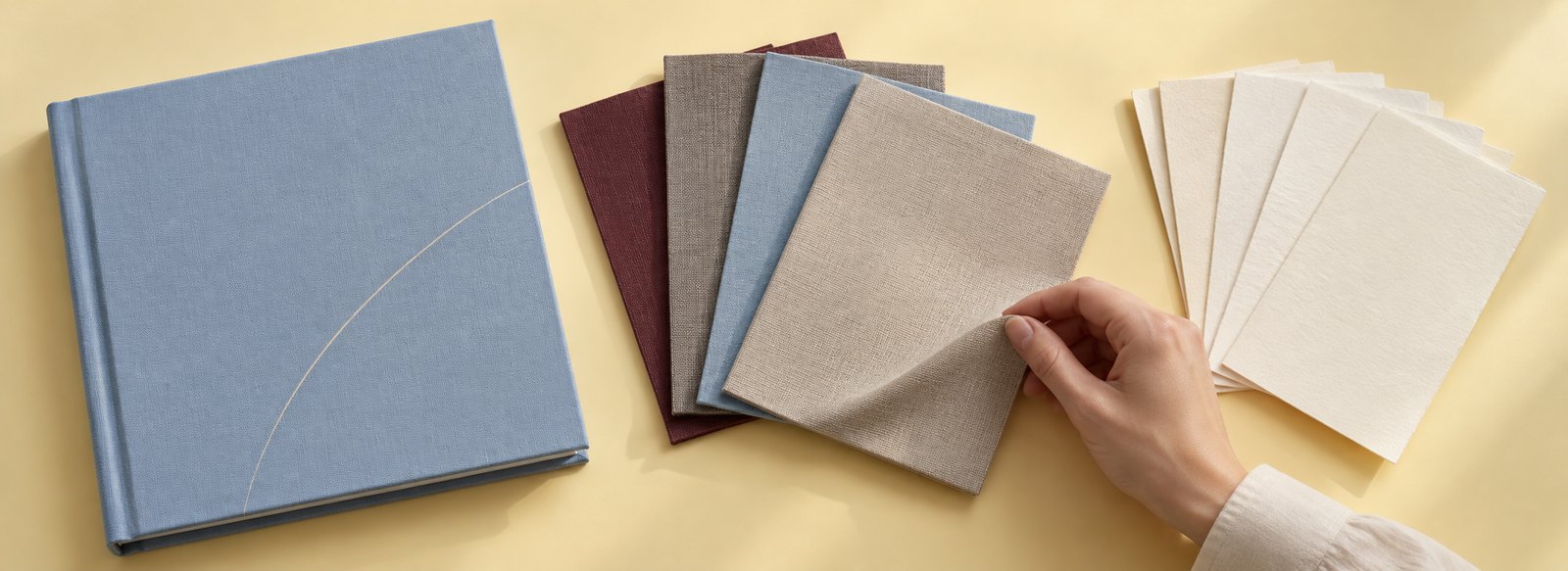 A blue clothbound book beside cloth swatches and paper samples